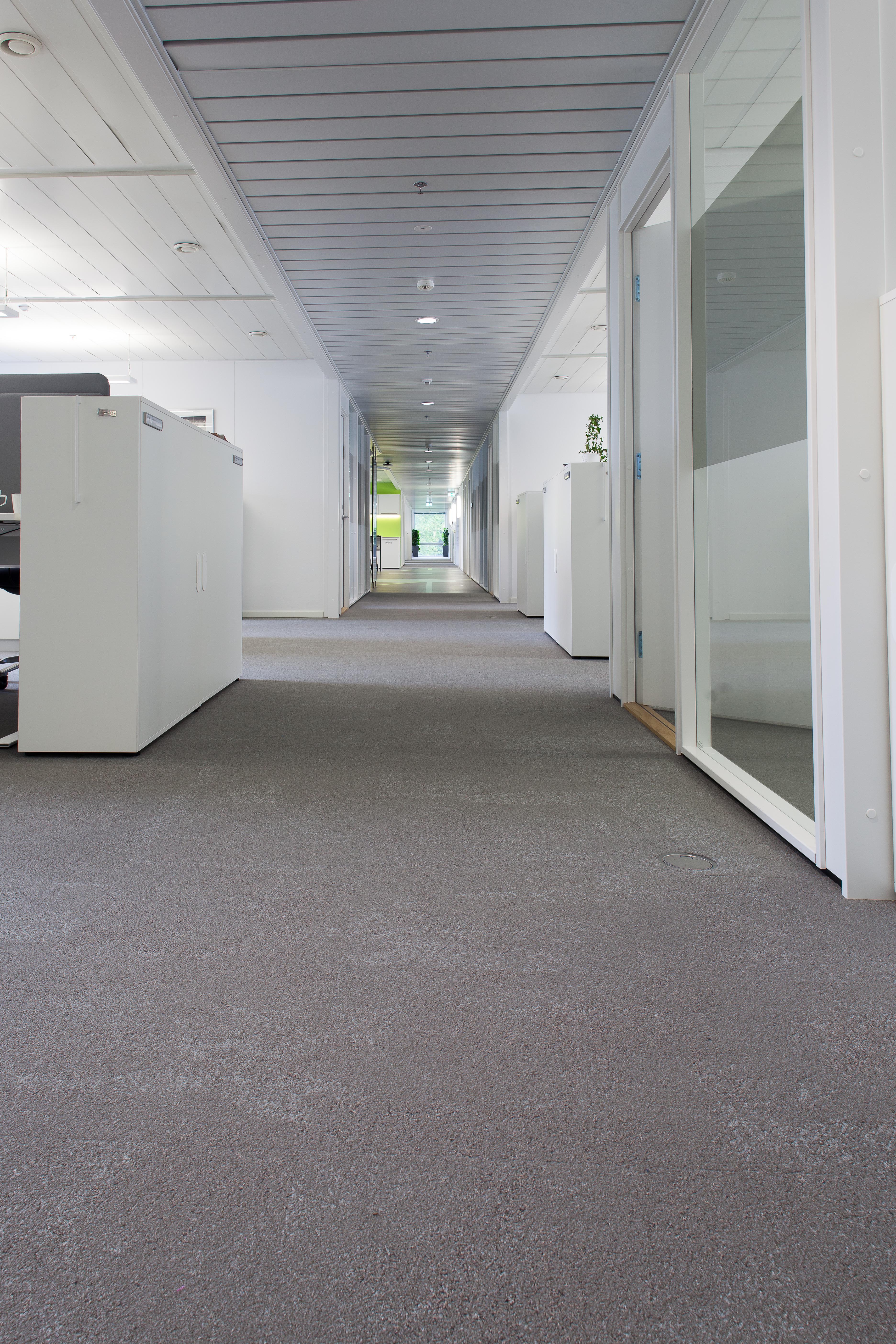 Det mørke linoleumsgulvet er vakkert avpasset til den omfattende bruken av teppefliser som skaper glimrende gangkomfort og gode akustiske forhold.