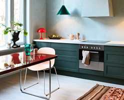 07. Kjøkkenet har en lettere, lysere atmosfære, med nyanser i blått og grønt. Røde aksentfarger skaper forbindelse med den tilstøtende spisestuen.