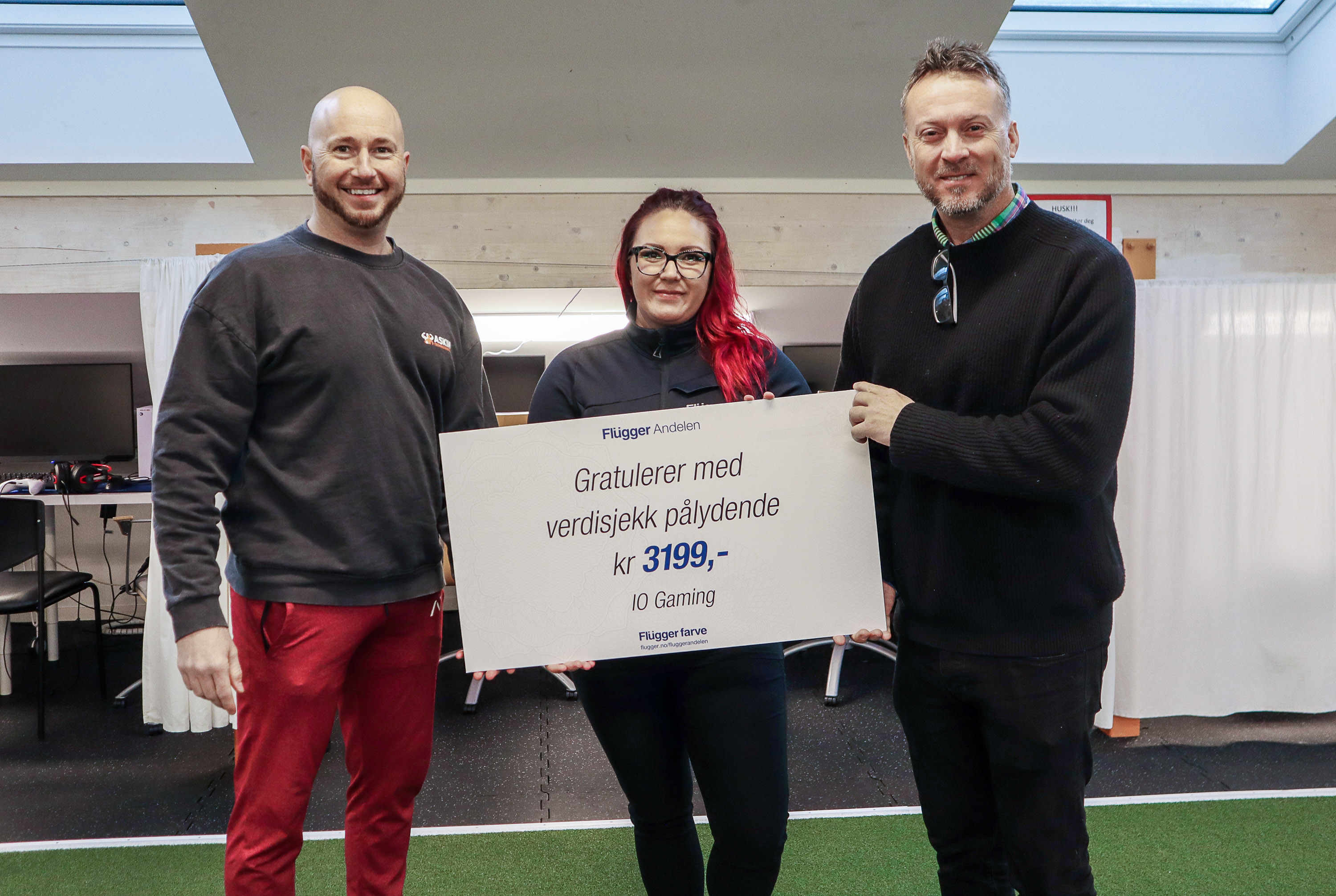 Bjørn Arild Skinnpungerud Kolshus får nå et tilskudd på 3 199 kroner fra Emmelie Bohl-Vaz, avdelingsleder Flügger Farve i Askim, og Steffen Eide.