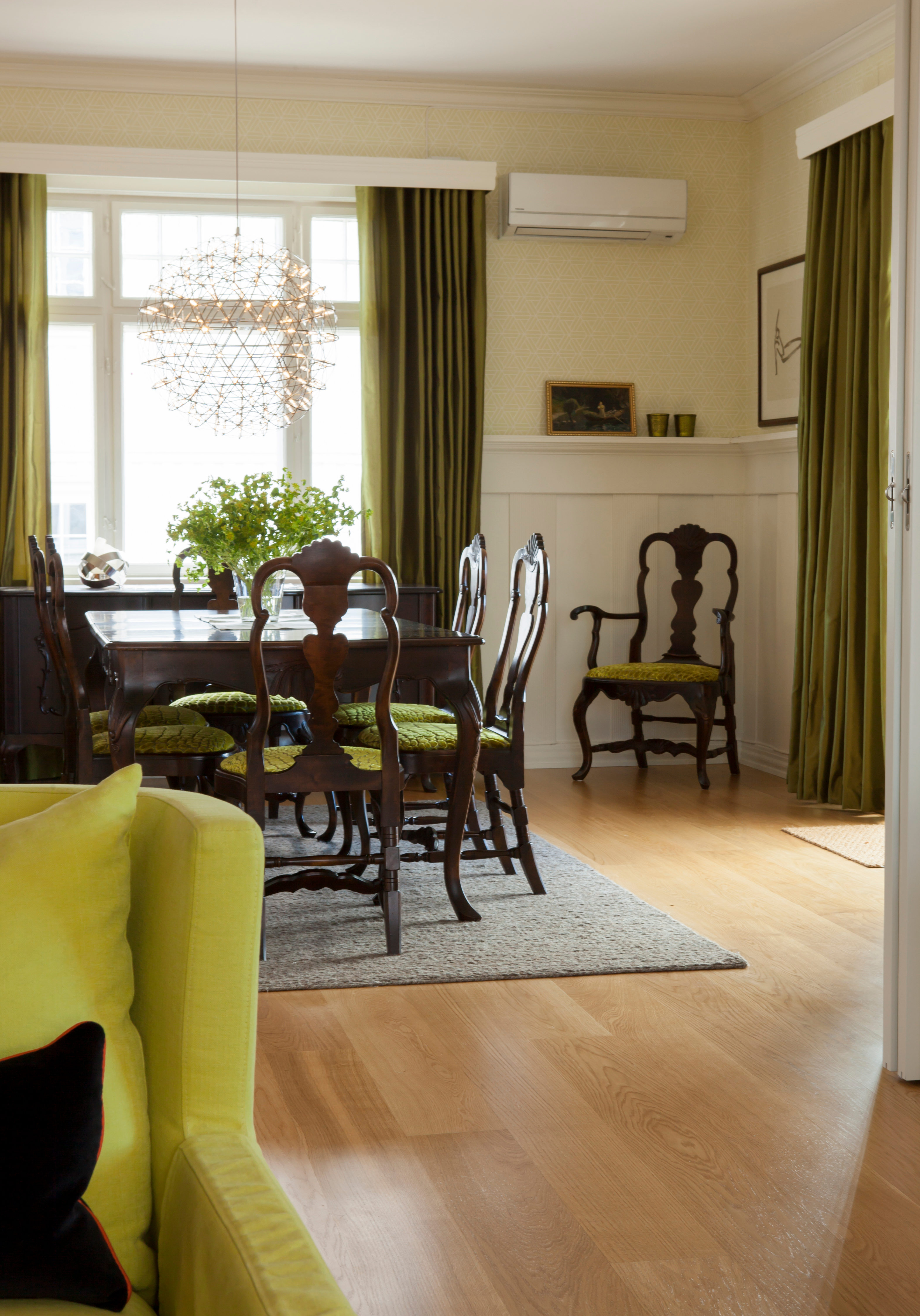 Lær deg å mikse nytt og gammelt. Et eksempel fra boken der en klassisk, lys spisestue i eik er beiset mørk og har fått mørk grønt møbeltrekk. Hovedfargen i rommet er grønt i ulike nyanser. Prikken over i-en er den moderne lampen over bordet. 