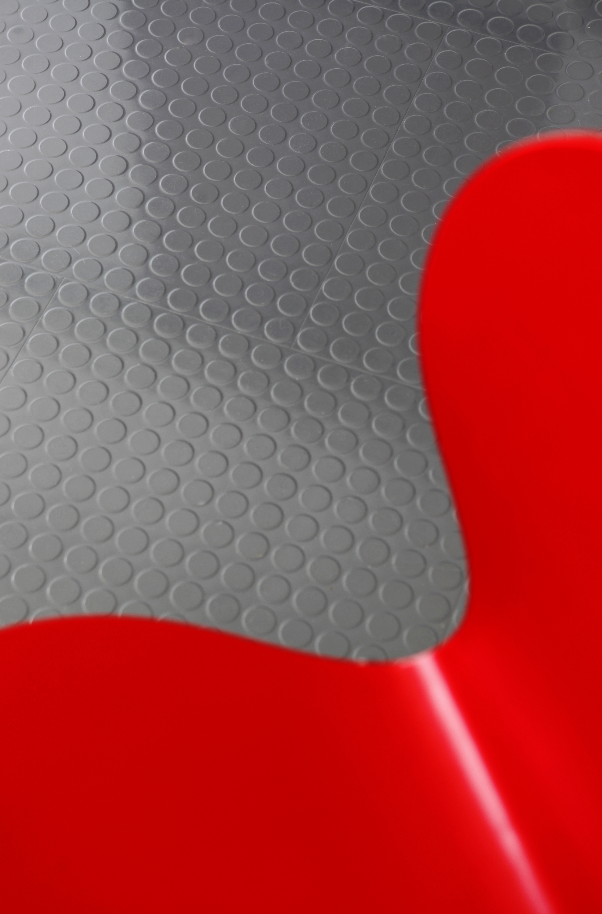 Det tøffe, praktiske gulvet mot en stol – knallrødt og grått er en frekk kombinasjon!