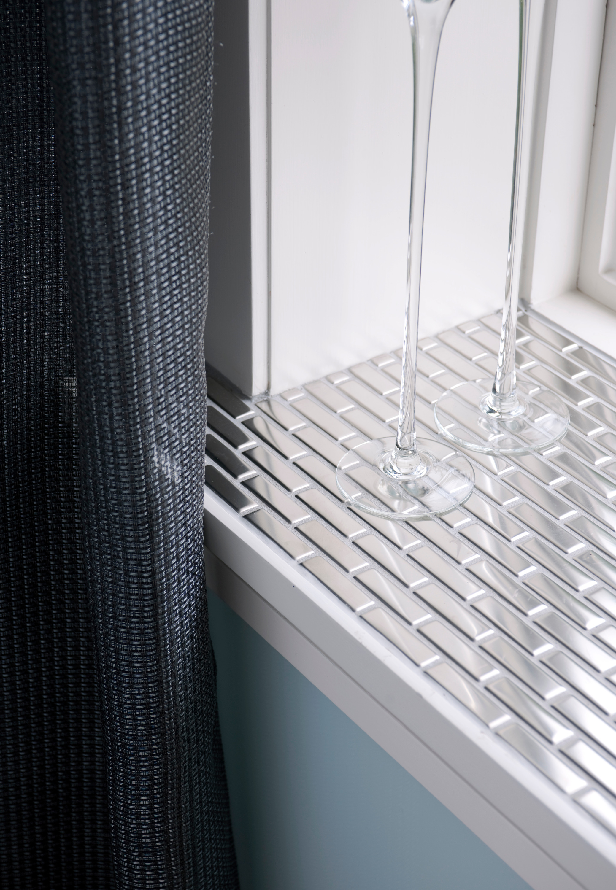 Fliser i rustfritt stål, blank mosaikk og høyglansmaling i vinduet sprer lyset inn i rommet. Foto: Espen Grønli/ifi.no