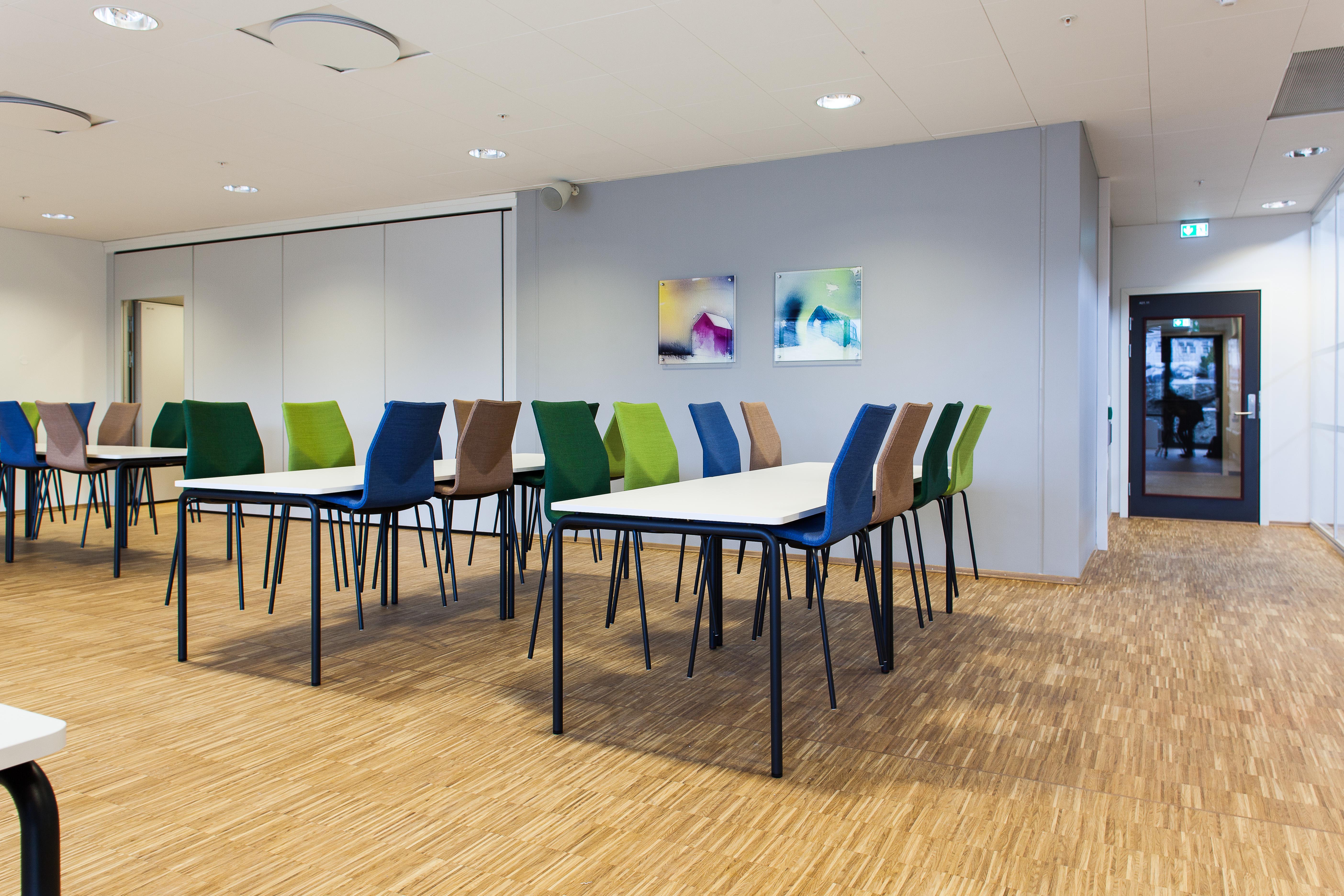 Å la stoler representere fargeinnslagene er en trend vi ser mange steder. Her blir det spesielt vellykket med matchende veggdekor.