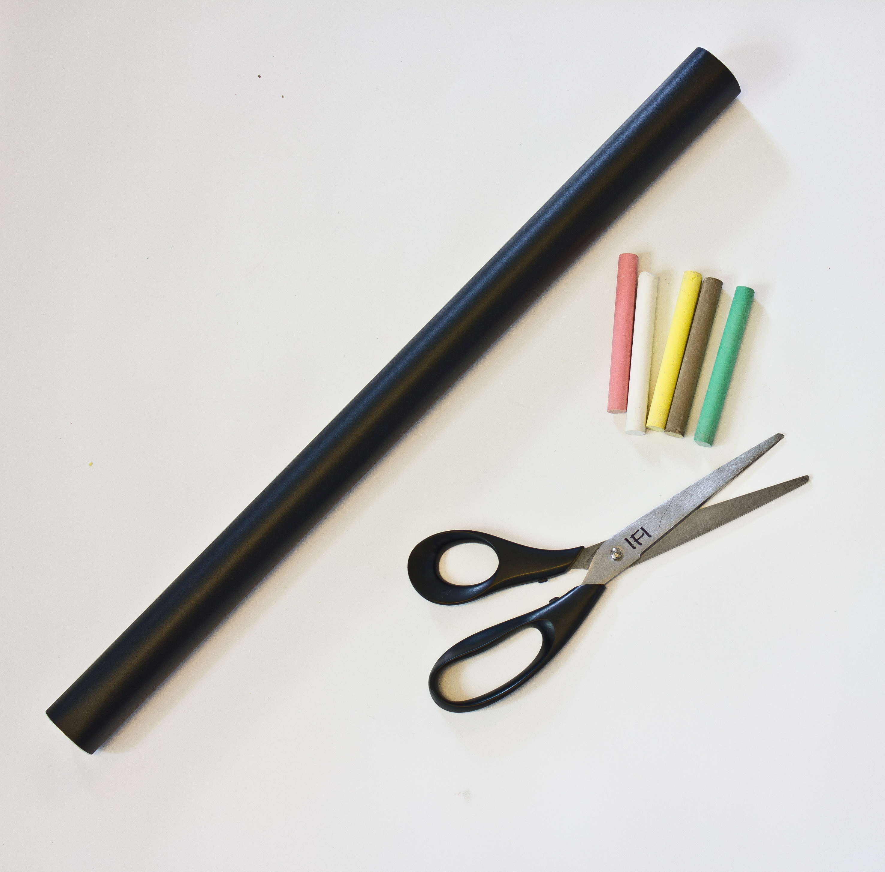 Du trenger en saks, en rull med tavlefolie og et par minutter. Krittet følger med i rullen med folie.