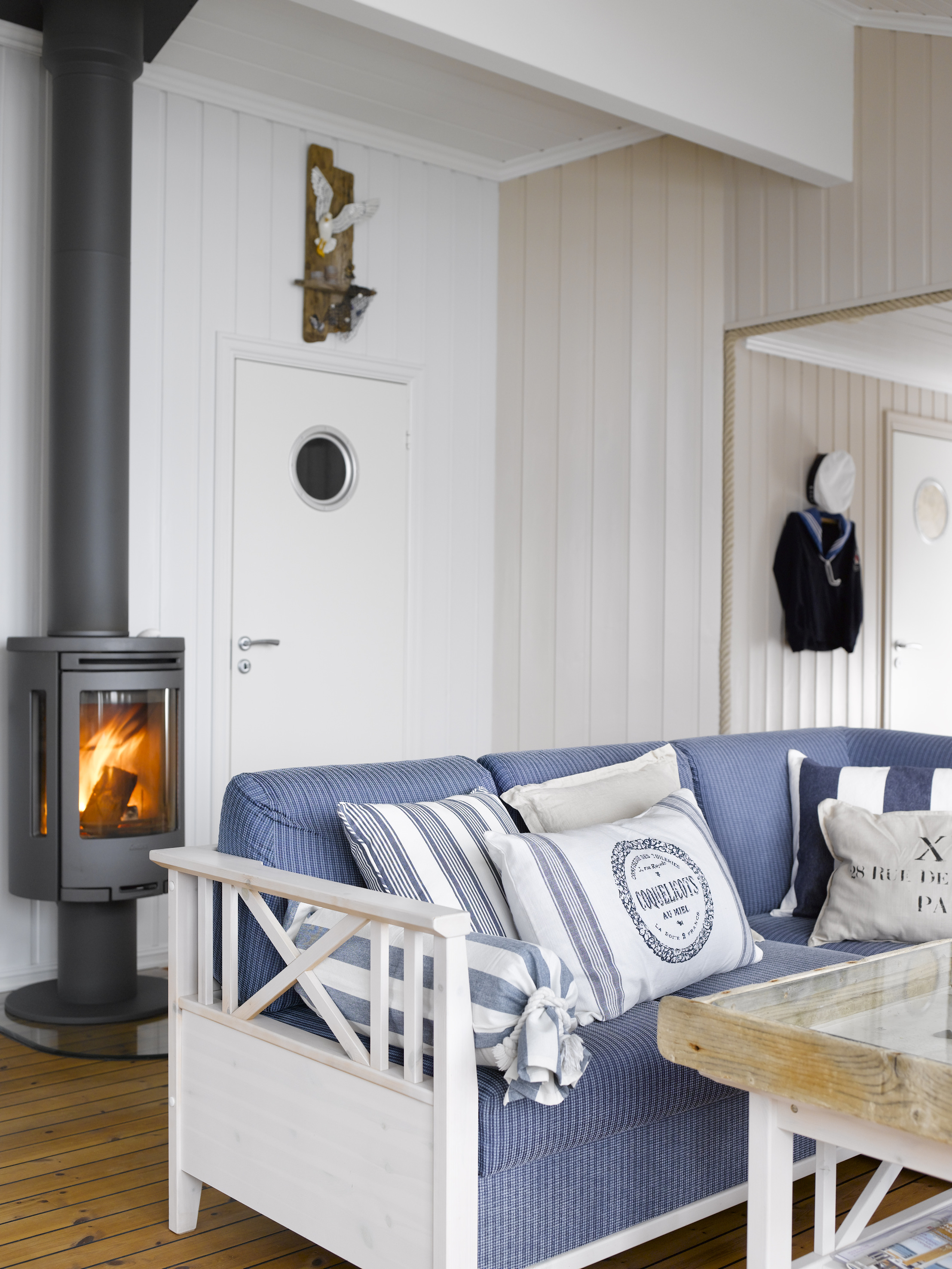 Veggen som fører mot baksiden av hytta har fått en hvitere farge enn veggene som møter solen og refleksjonene fra sjøen. De to veggfargene møtes fint i hjørnet. 