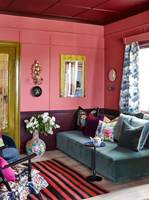 STUE: En rosa stue med mye liv, men som allikevel dempes litt av andre farger, tekstiler og mønster.