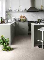 PÅ KJØKKENET: En god arbeidsstilling på kjøkkenet krever et gulv som er mykt og behagelig å stå på. Her vises Tarkett Extra Stylish Concrete i fargen Light Grey. 