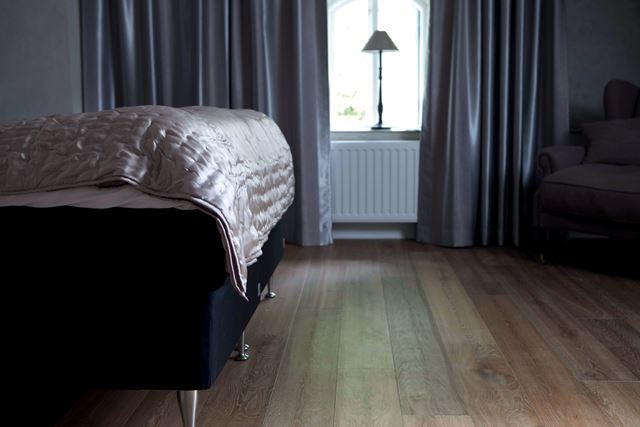 HOTELLSTIL: Gå for et mørkt gulv på soverommet. Her er det en bruntonet slittsgulv fra Alfort. (Foto: Alfort)