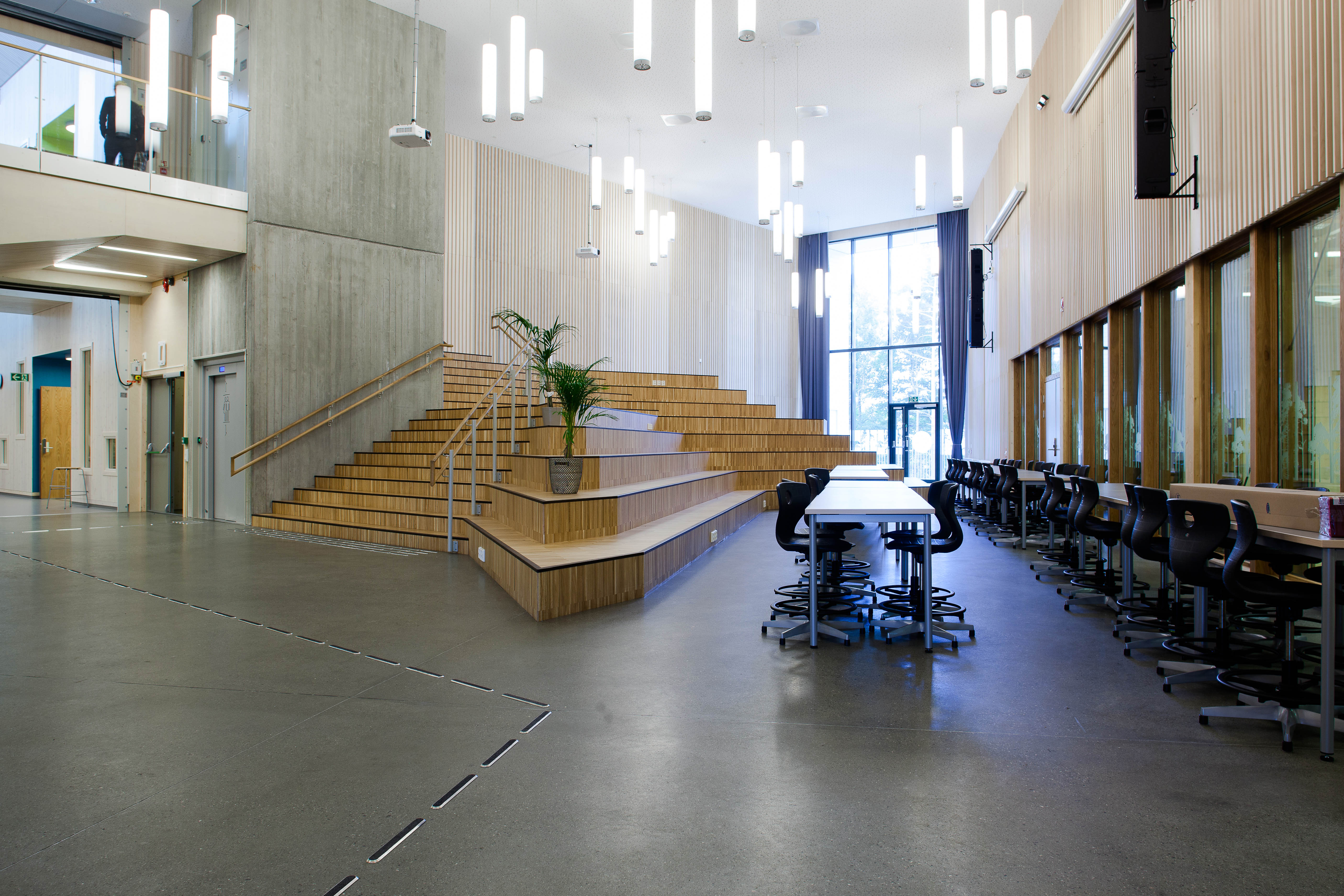 Allerede ved hovedinngangen blir vi møtt av et gedigent auditorium som fremstår som et naturlig knutepunkt for skolen og kan benyttes til store møter, filmfremvisning og liknende.