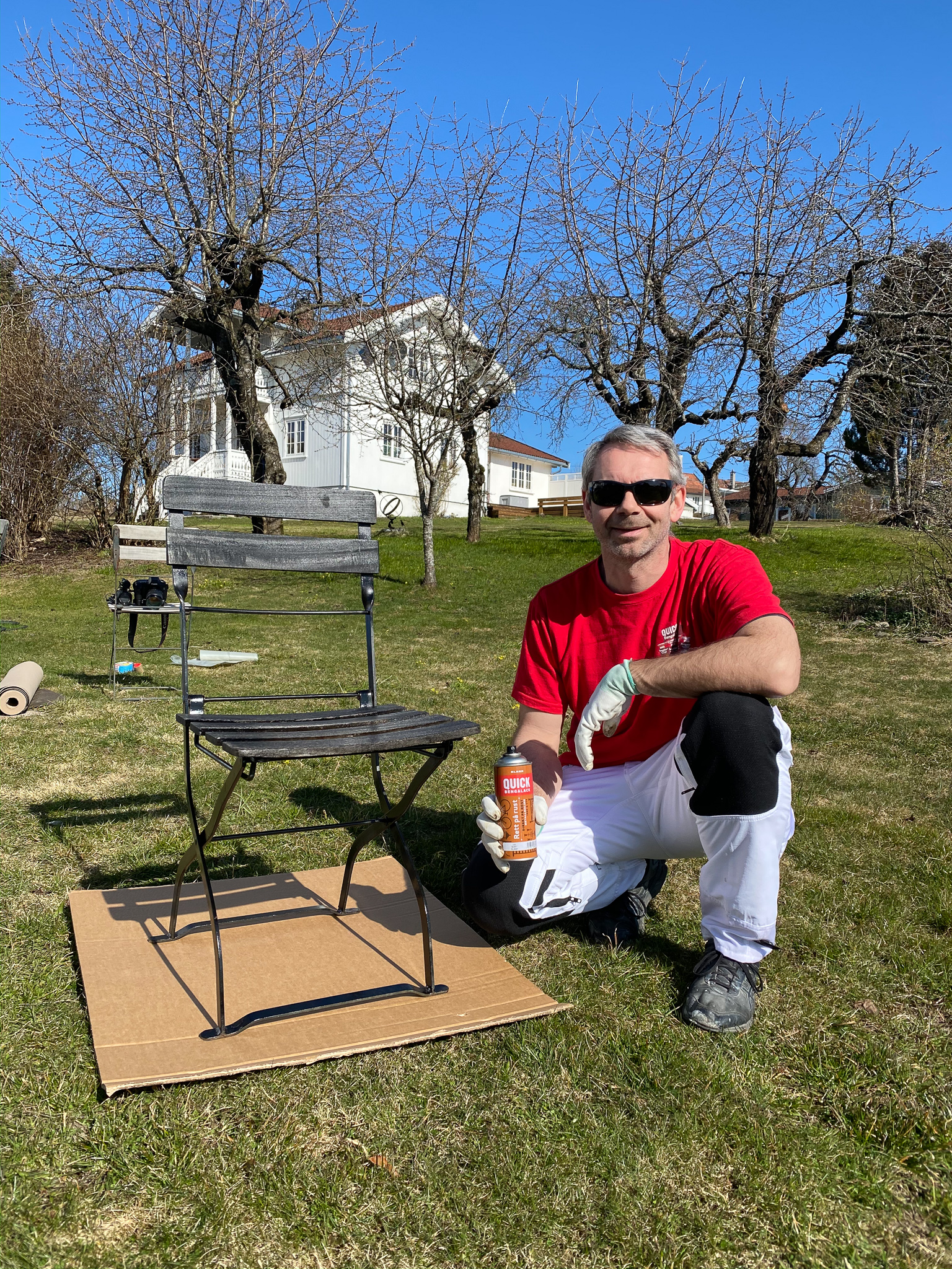 Teknisk sjef Thor Ingar nyter vårsola mens han sprayer stoler.