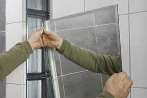 Bruk dobbeltsidig tape ved ettermontering av speil på bad.