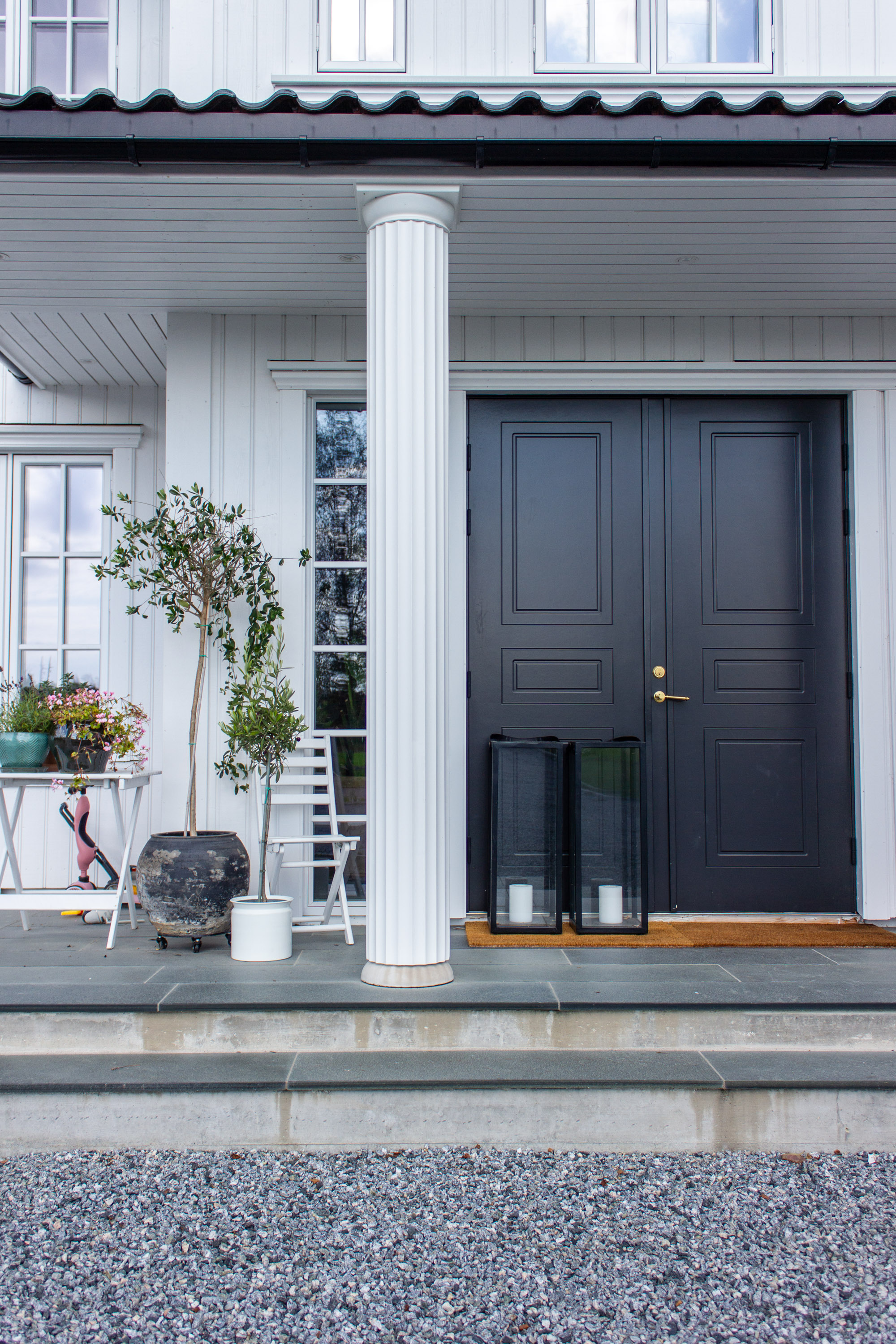 svart dør søyler hvitt hus
