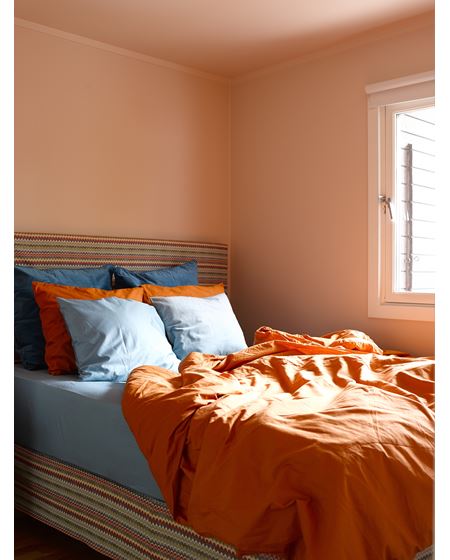 På soverommet er den oransje tråden fra kjøkkenet tatt opp, i en dempet, pudderoransje variant  (S 1010-Y70R). Tak, vegger og listverk er malt i én og samme farge, noe som forsterker fargeeffekten. 