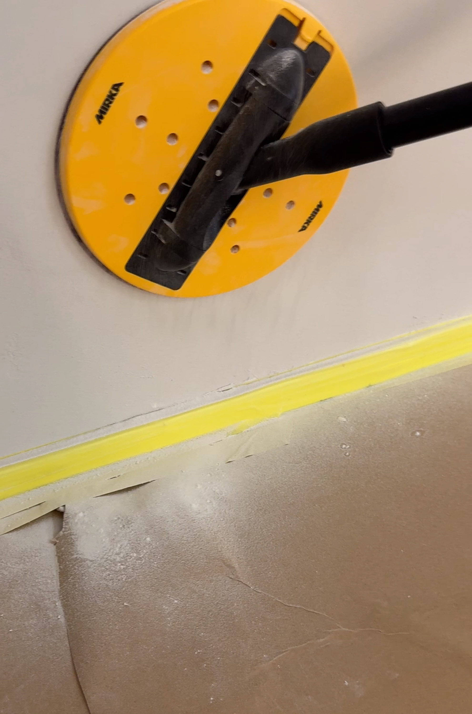 Gipsstøv på gulv under sliping av gipsvegg.