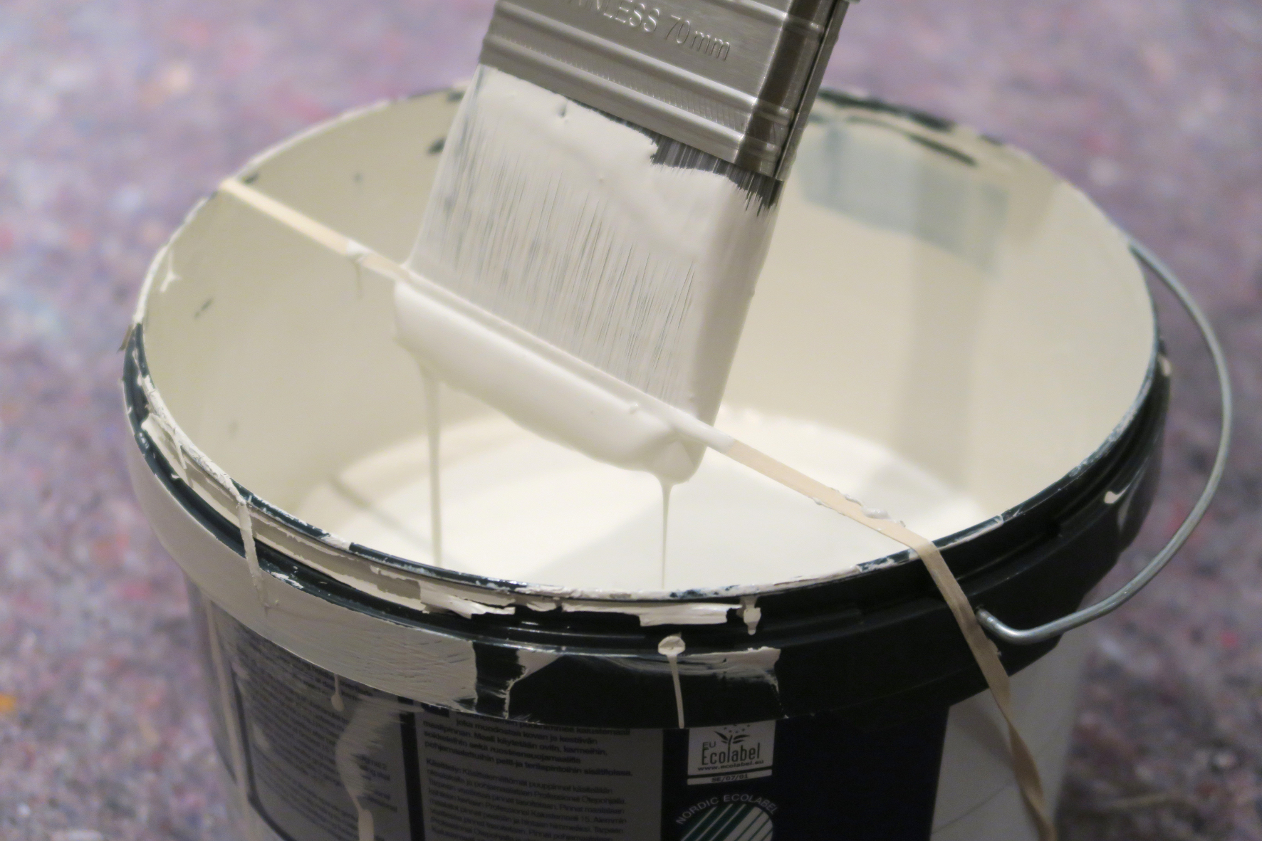 STREKK STRIKKEN: En strikk rundt malerspannet gjør det enkelt å tørke av penselen når du maler. 