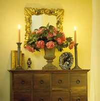 Fete gullrammer og frodige blomsterbuketter skal det være. Klassiske lysestaker i bronse og jernurne er helt i stilen.