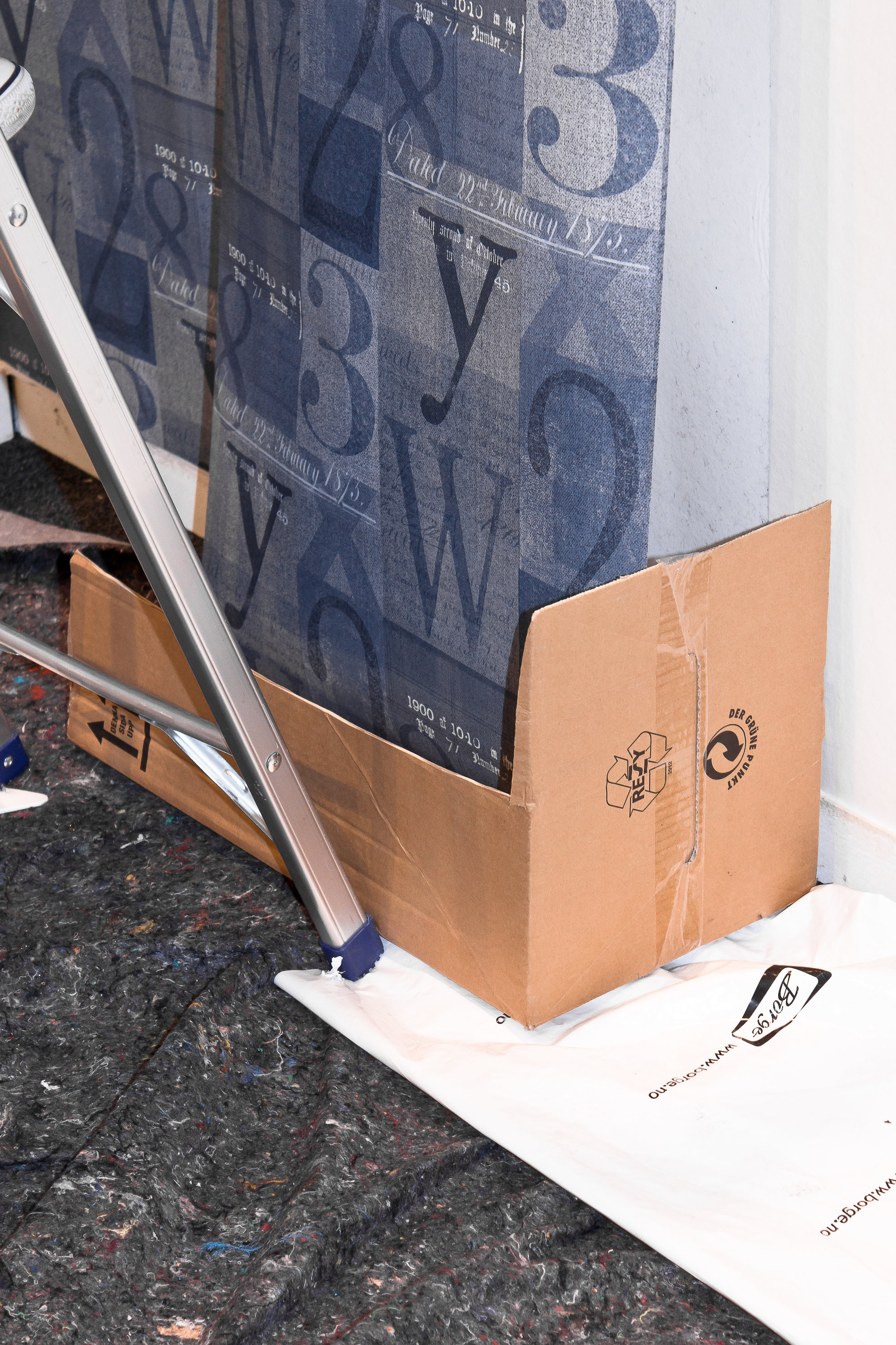 SMART: Legg hele tapetrullen i pappesken på gulvet foran der du skal henge tapetet opp. 