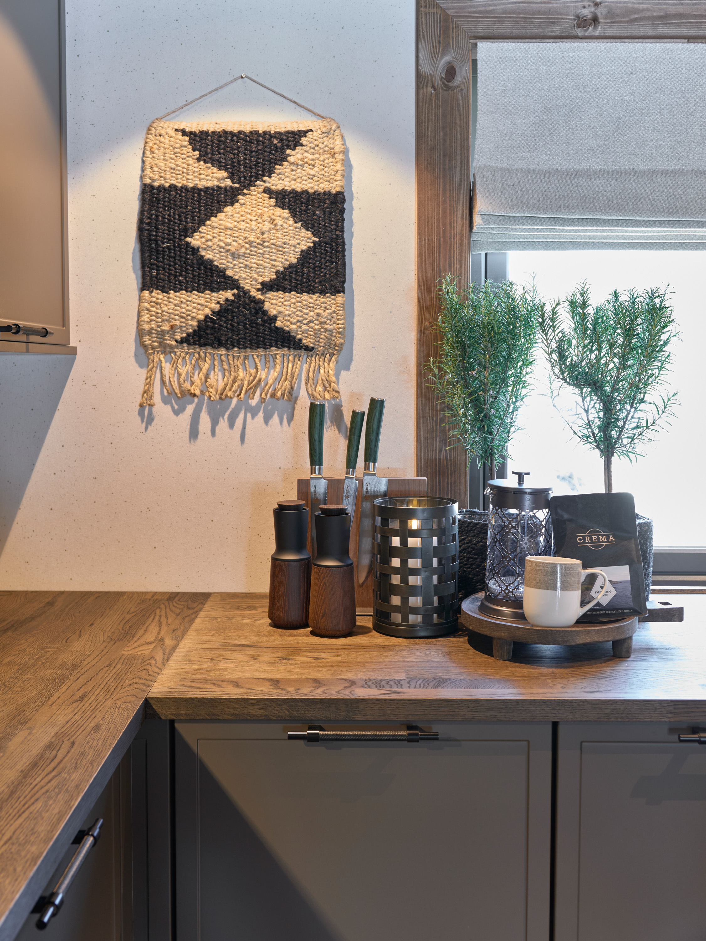 kjøkkenbenk ved et vindu, lyst tapet med diskret mønster på veggen.