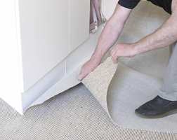 Grovtilpass teppet til gulvet ved å skjære av overflødig teppe. Da blir den lettere å jobbe med. Fintilpassingen gjøres senere.