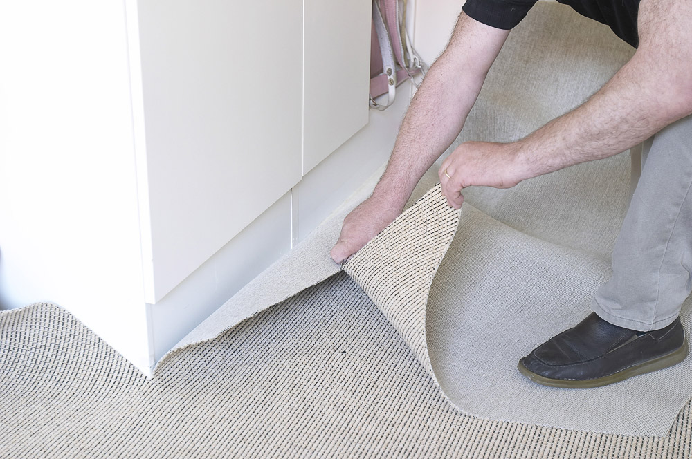 skjærer teppe mot vegg 