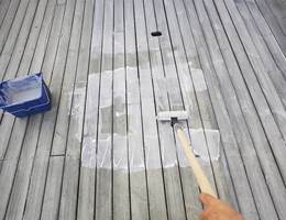 Terrasseoljen påføres feltvis med en malerrull. Deretter brukes en bred beispensel i lange drag for å stryke oljen skikkelig ut og komme mellom bordene. 