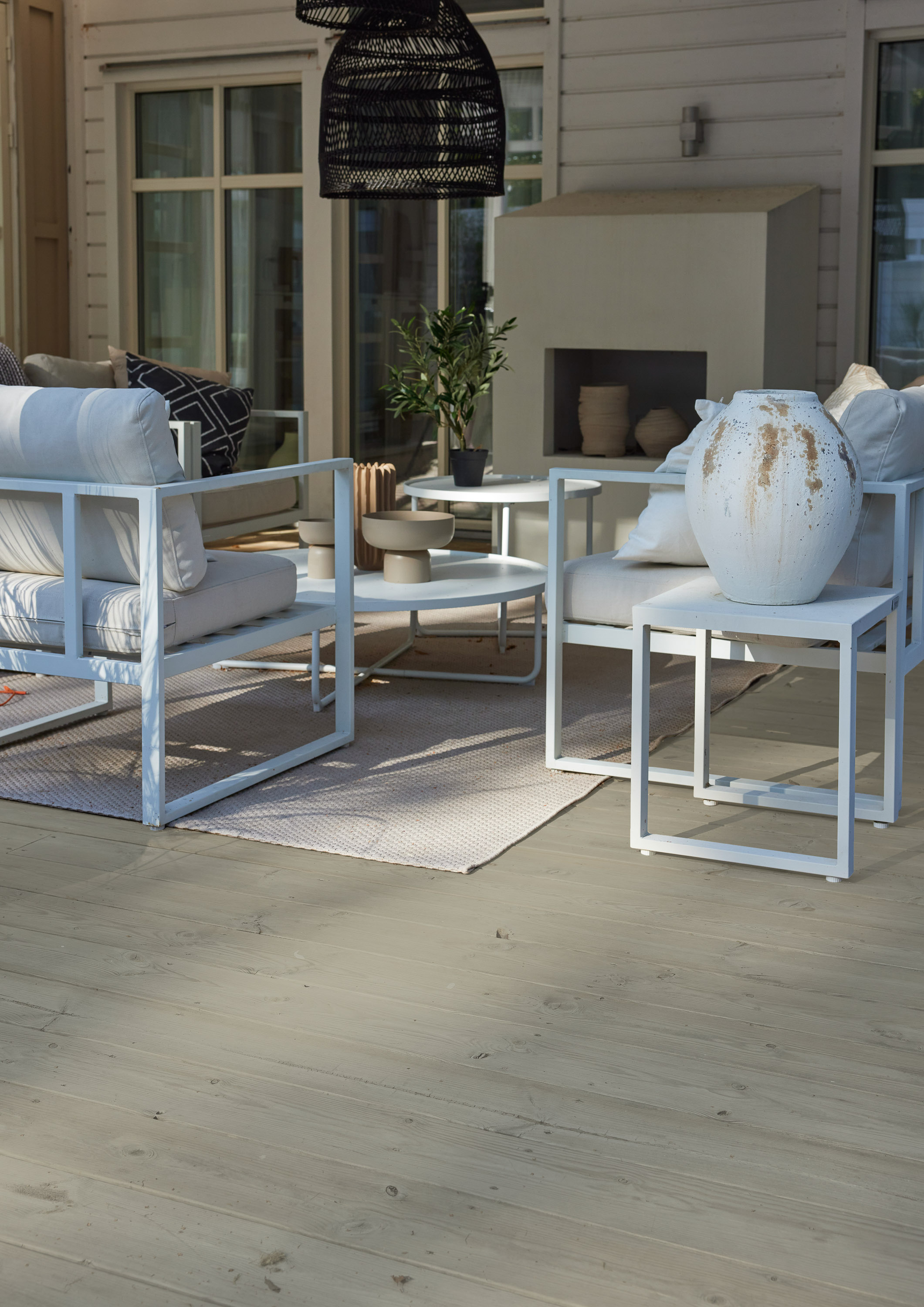 Overbygget terrasse ved hvitt hus