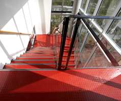 Det er lagt ca. 3.500 m2 gummibelegg - i en grå hovedfarge, men med sterke innslag som rød og grønn i trapperom.