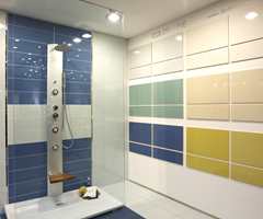 Blått innslag i dusjkabinettet, mens utstillingen på vegg viser matchende flisstørrelser. (Höganäs).