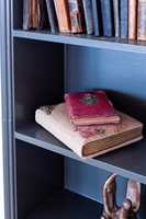 NISJE: Den mørkegrå fargen er fin bakgrunn for bøker, og matcher fargenyansen på sengegavl, kiste og tapetet i garderoben. 