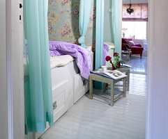Lys turkisfarge illuderer både frisk luft og lys. Flortynne gardiner gir rommet et svalt inntrykk og skjermer samtidig sengen. 