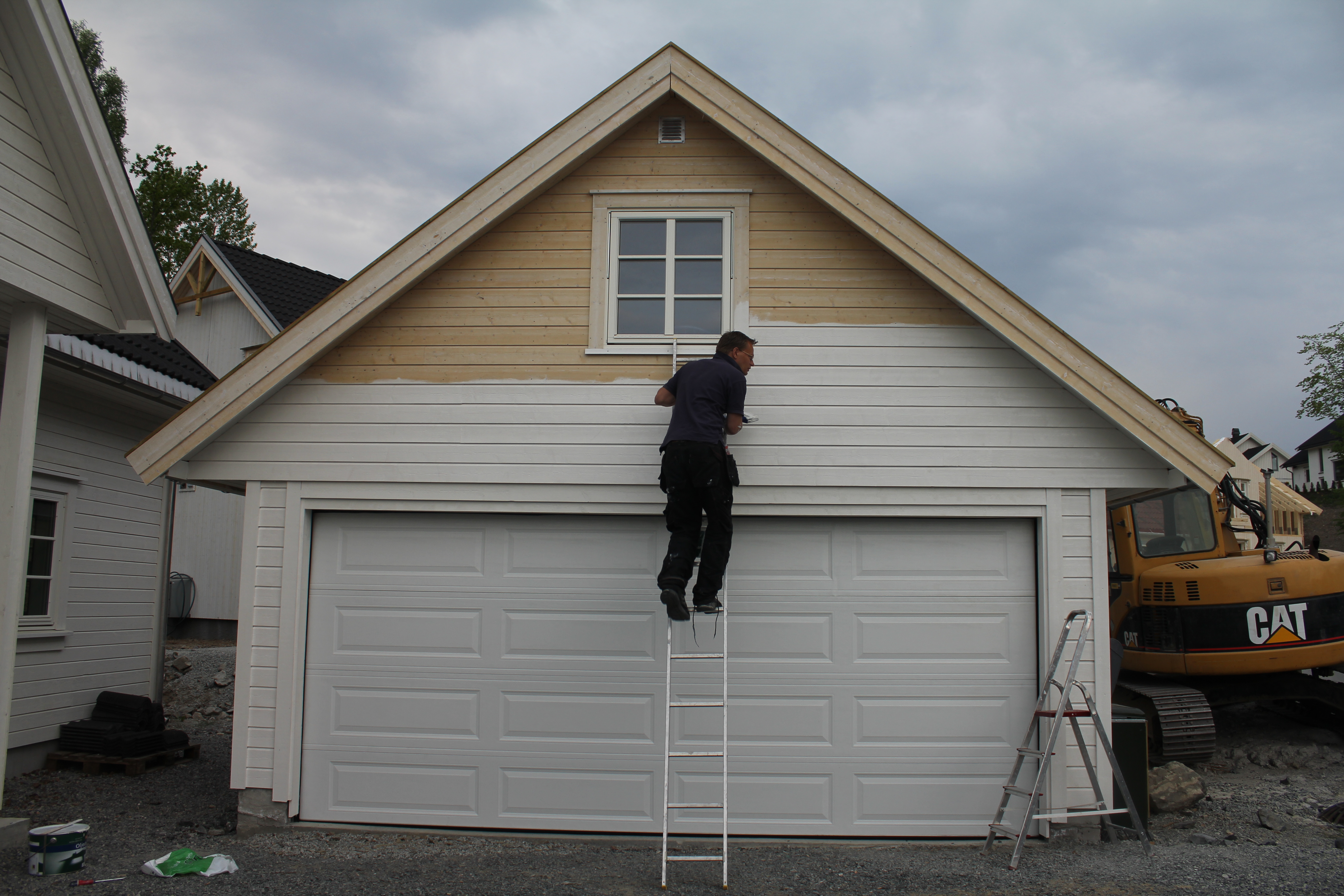 mann som grunner kledning på garasje