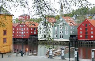 Vi kommer sjøveien til Trondheim og skal se på byens farger. Men fra den kanten forskanser byen seg bak en borg av gråsvarte hus-kolosser og tonnevis av strekkmetall i trapper og gangbroer á la 2018. 