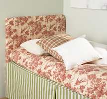 Sengen med ny gavl, sengeteppe og puter, en hyggelig mix av ruter, striper og mønster.