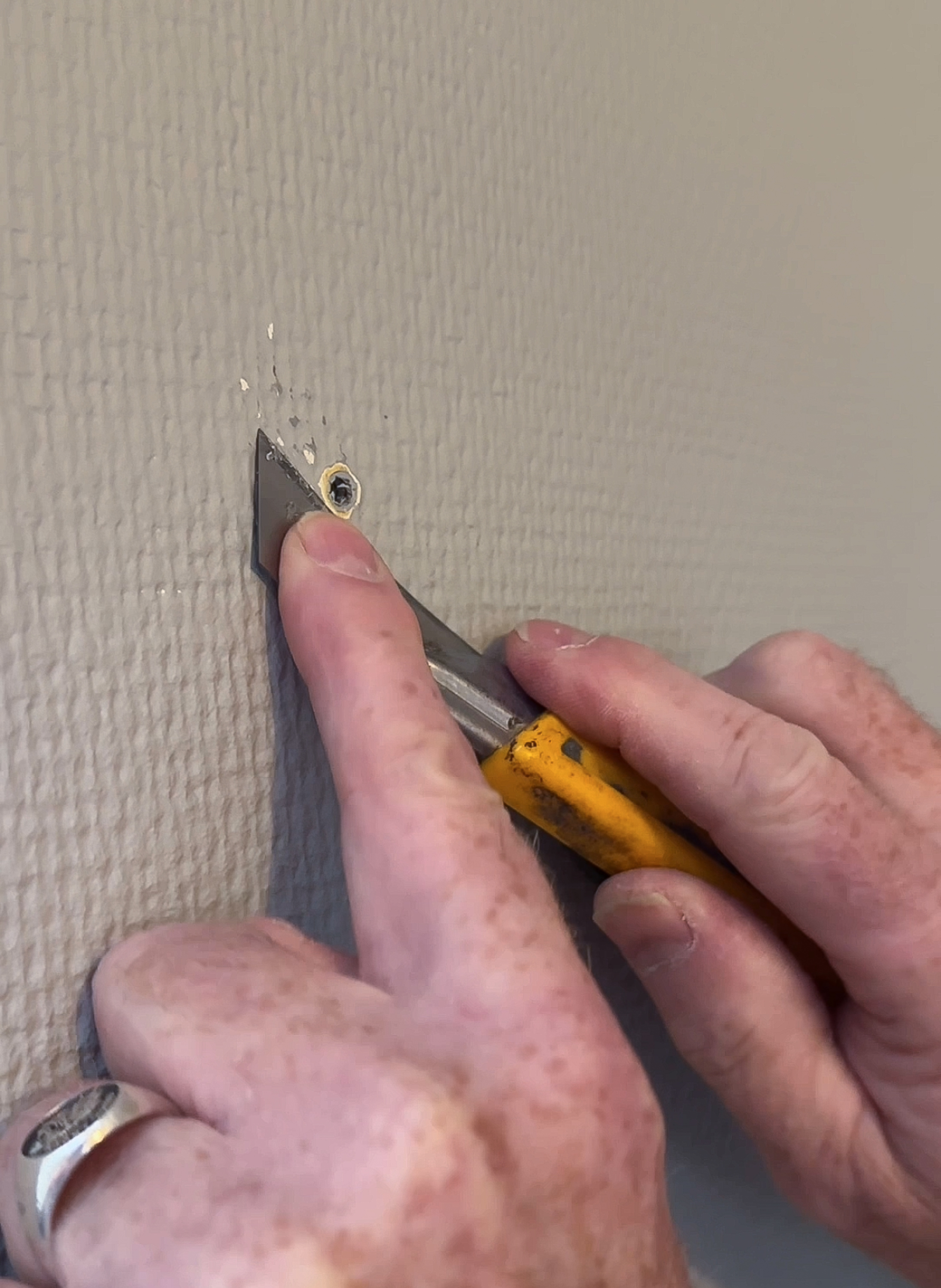 To hender holder en kniv og skjærer på glassfiberstrie