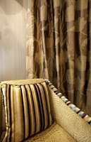 Møbelstoffene fra Harlequin matcher her gardiner og tapet, gardinene trendriktige med store mønstre.