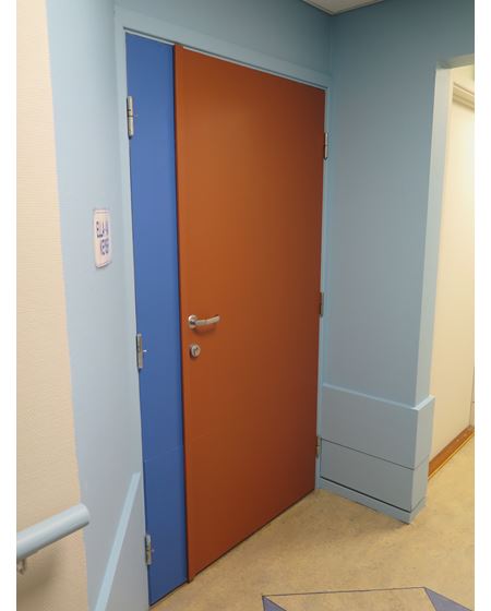 Korridor med blå nisjer og varmoker dører.