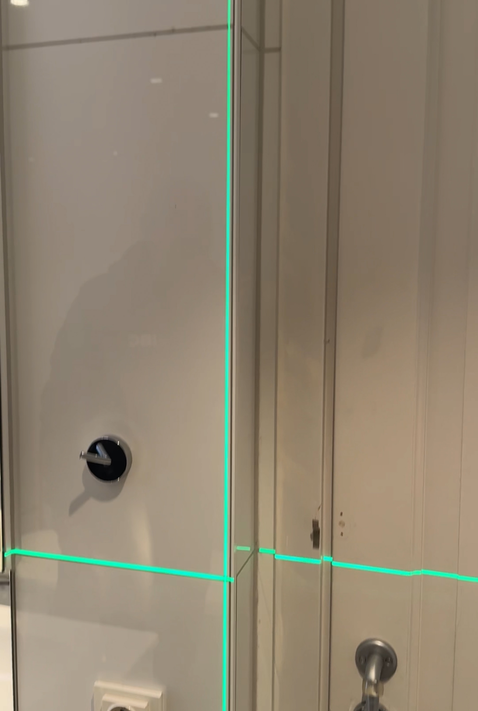 laser som illustrerer følgelinjer ved montering av flis på vegg.