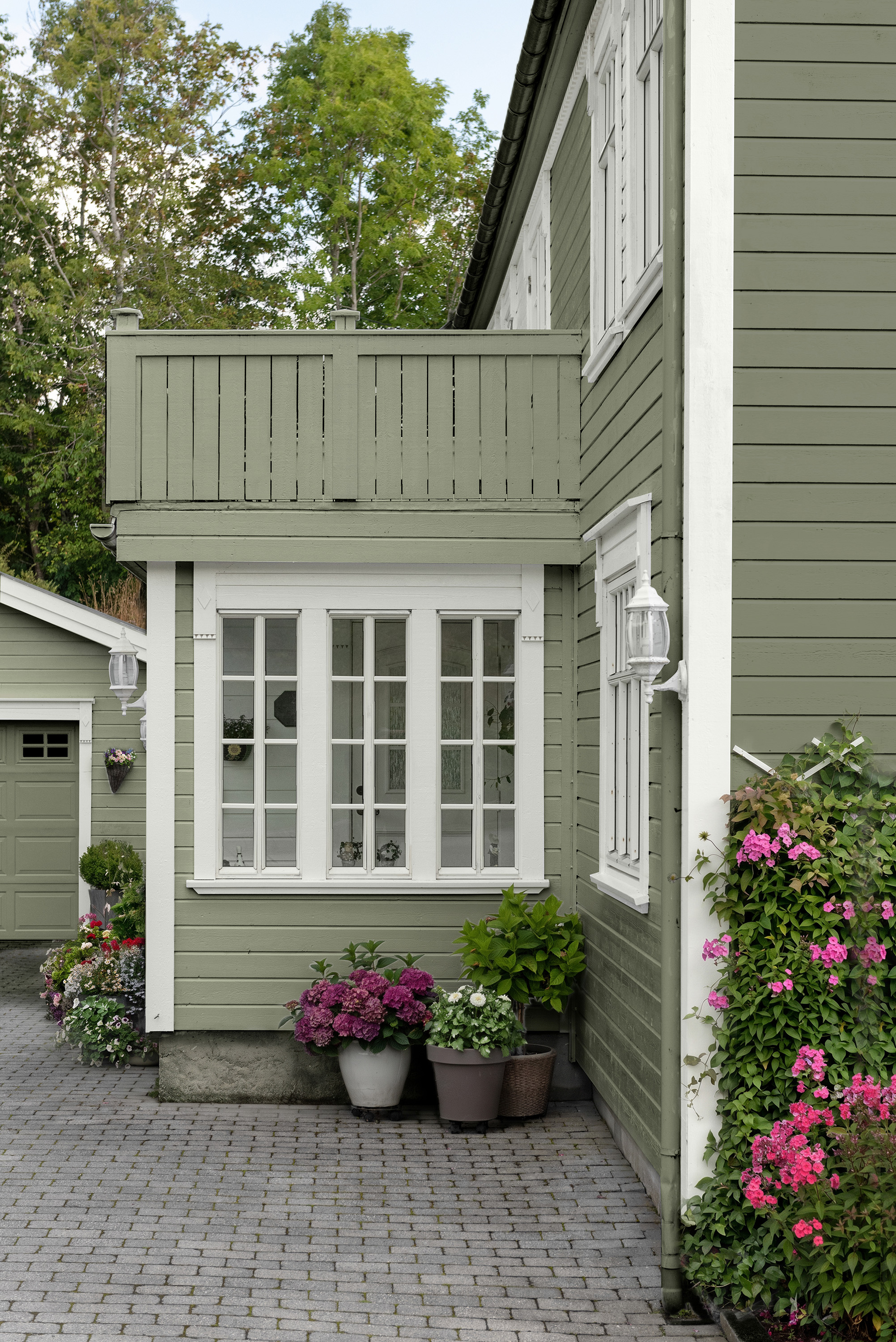 grønn fasade med hvite detaljer 