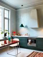HARMONI: Vinduene på kjøkkenet er malt i samme duse nyanser av blågrønt som veggene. Med kjøkkenfronter i en mørkere nyanse av samme farge og en liten rød kontrast er dette en enkel palett som skaper et rolig rom. (Foto: Pure & Original Paint)