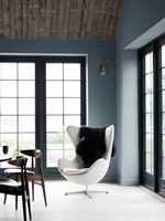 RAMME: Farge og nyanse må avstemmes i forhold til ønsket atmosfære og stil på rommet. I dette moderne rommet blir den mørke fargen en spennende ramme rundt utsikten. Veggene er malt i Turkish blue no 54 fra Flügger. (Foto: Flügger)