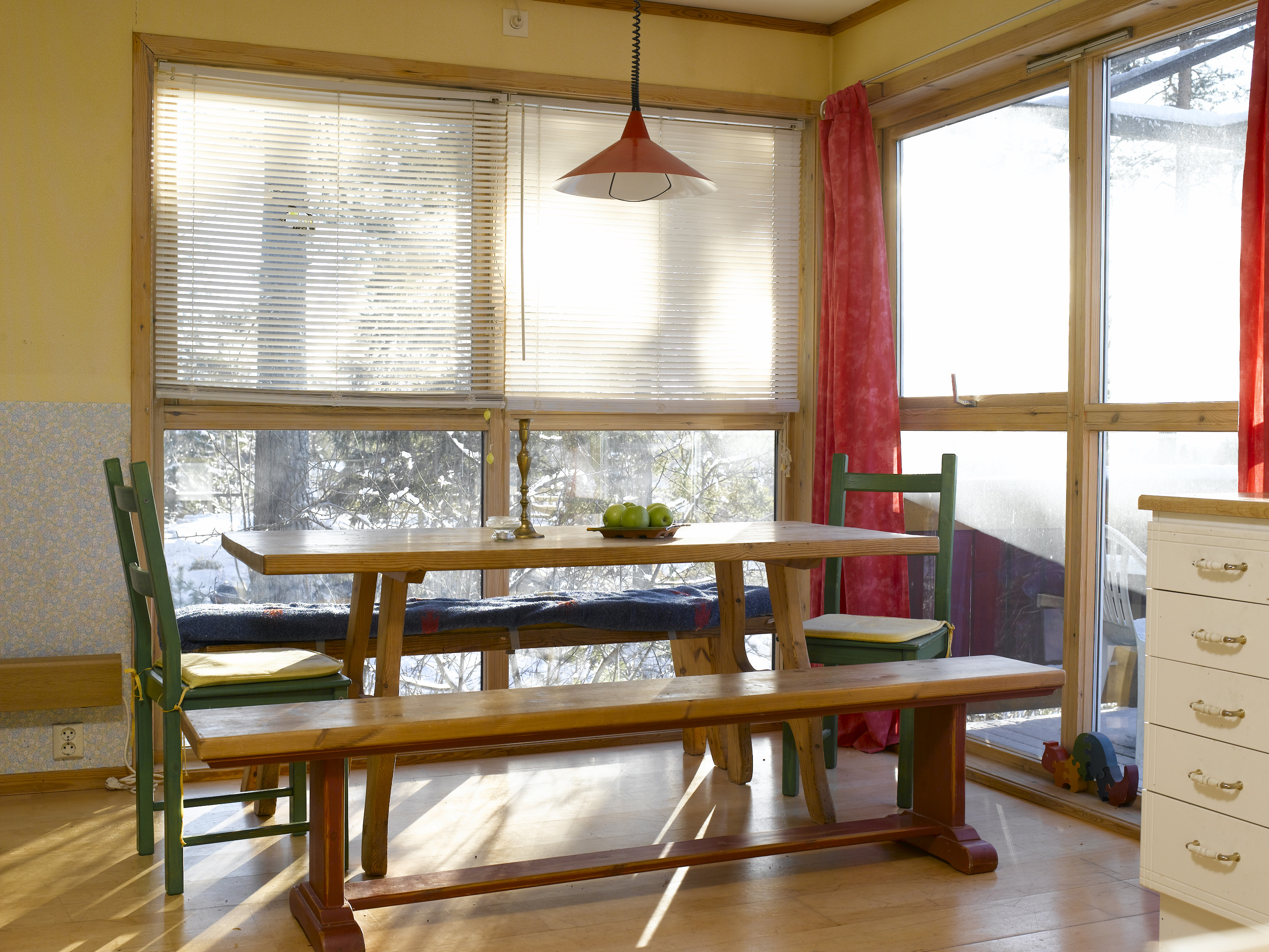Spiseplassen før, med noe utdaterte farger; umalt treverk og gulnet tregulv. 