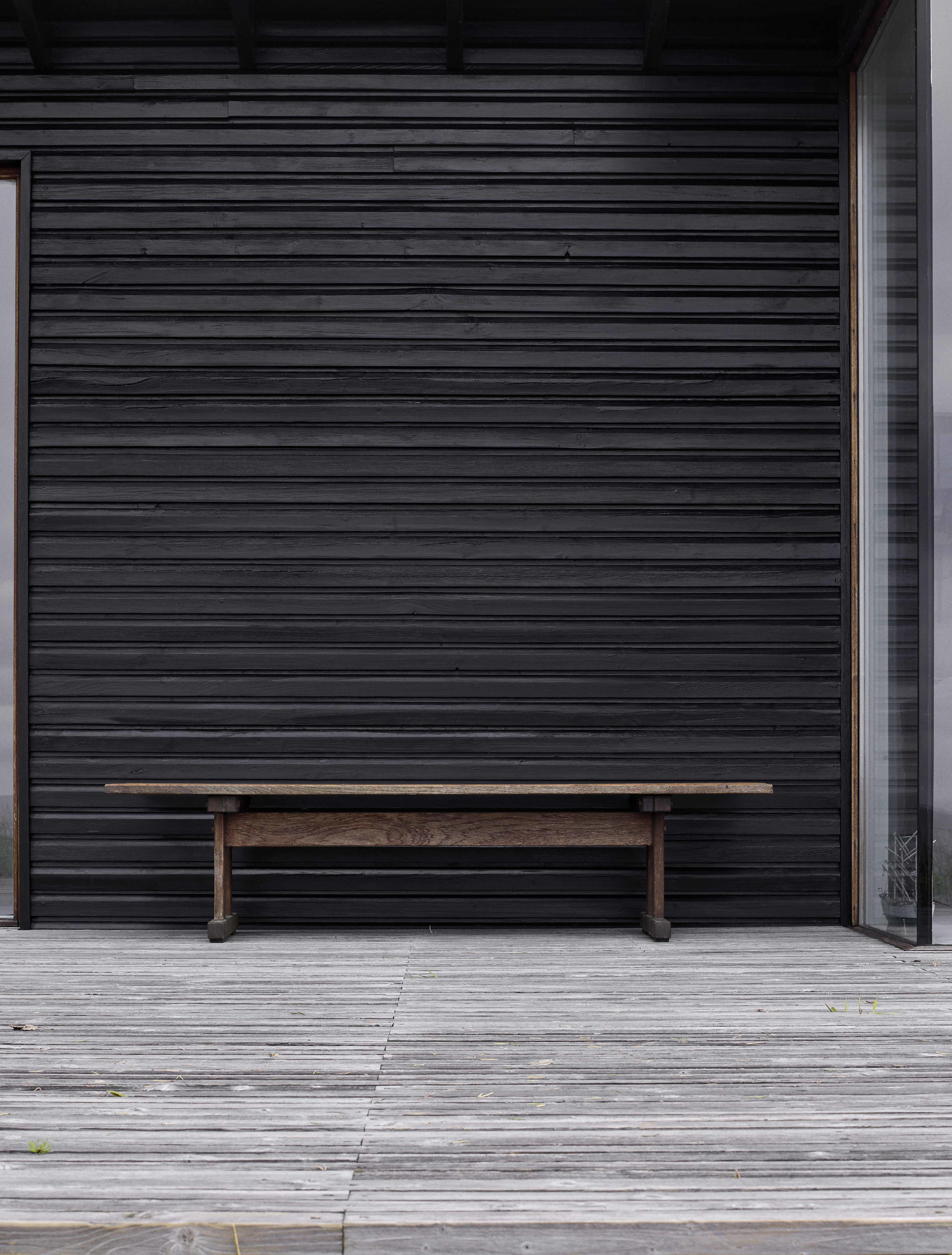 sortmalt fasade med terrasse foran